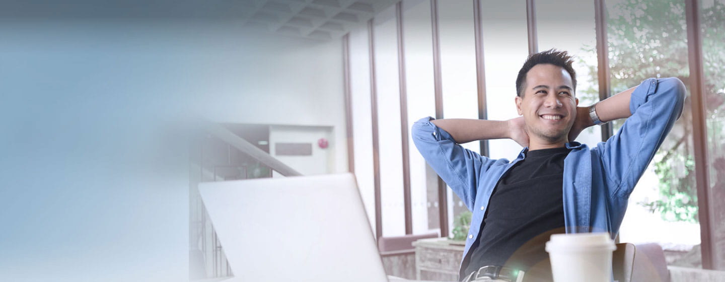 Relaxed man smiling in front of the laptop