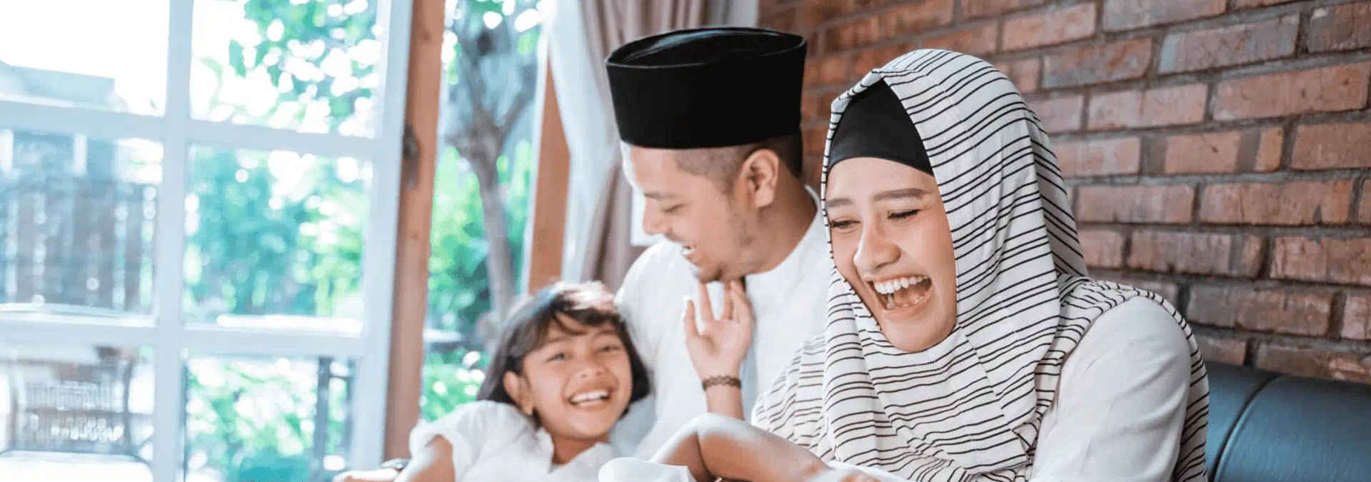 Muslim family playing with their babies on the sofa 